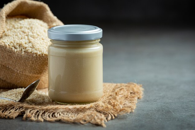 Tahini e semi di sesamo su sfondo scuro