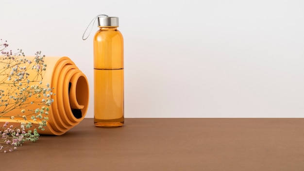 Tappetino da yoga arancione e bottiglia d'acqua