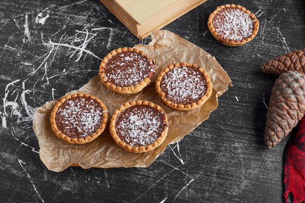 Tartalette al cioccolato su un pezzo di carta.