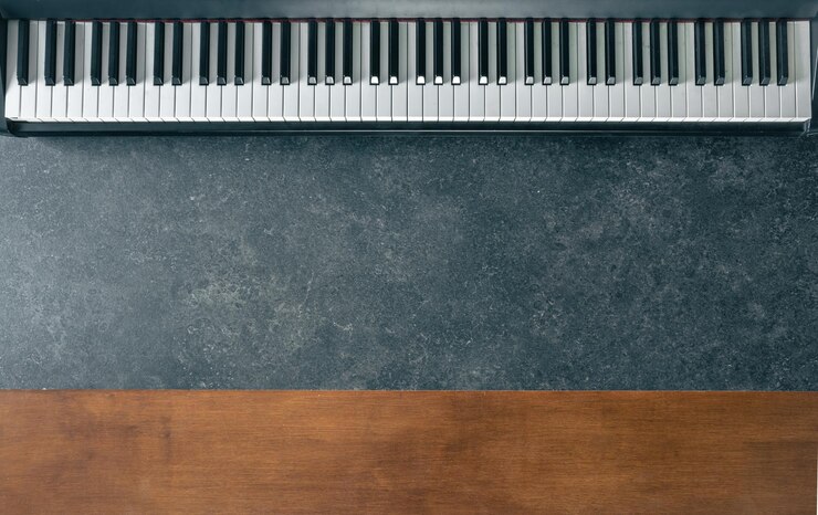 Foto gratuito tastiera di pianoforte su un marmo scuro e superficie in legno vista superiore