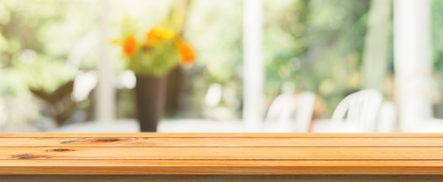 Tavola di legno bordo vuoto sfocato sfondo. Prospettiva tavolo di legno marrone su sfocatura in sfondo caffè caffè. Banner panoramico - può essere utilizzato come modello per la visualizzazione o la progettazione dei prodotti di montaggio.