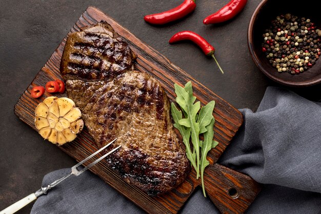 Tavola di legno con carne alla griglia e condimento