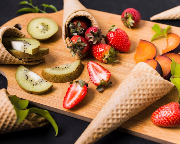 Tavola di legno con coni gelato con frutta