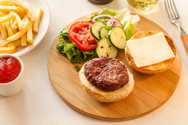 Tavola di legno con hamburger e patatine fritte