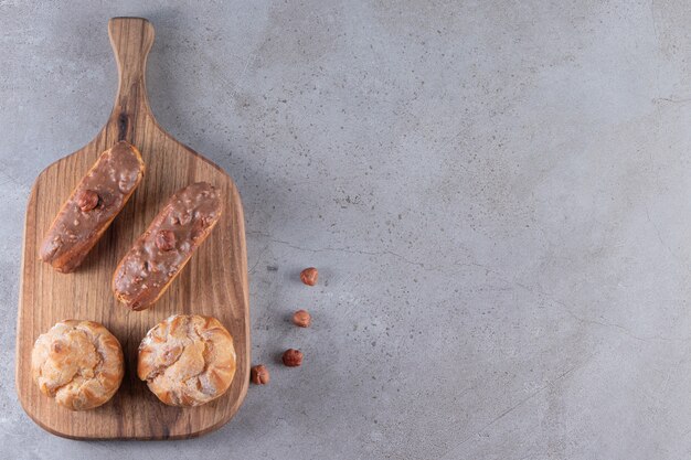 Tavola di legno di profiteroles dolci e bignè sul tavolo di pietra.