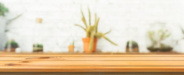 Tavola di legno tabella vuota sfocata sfondo. Prospettiva tavolo di legno marrone su sfocatura in sfondo caffè. Banner panoramico - può essere utilizzato come modello per la visualizzazione o la progettazione di prodotti di montaggio.