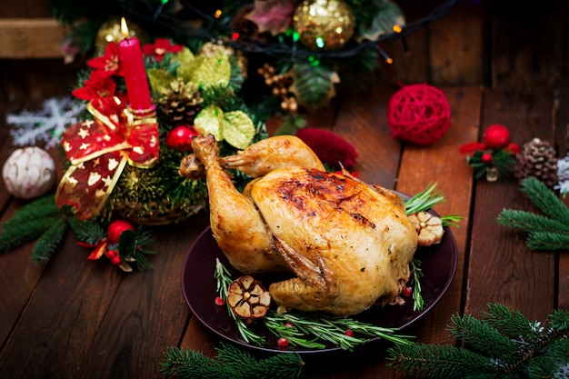 Tavola di Natale servita con un tacchino, decorato con tinsel e candele luminose