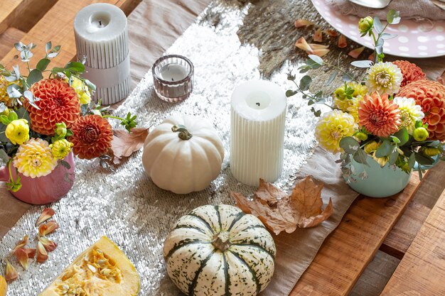 Tavola festiva con candele di zucca e fiori di crisantemo