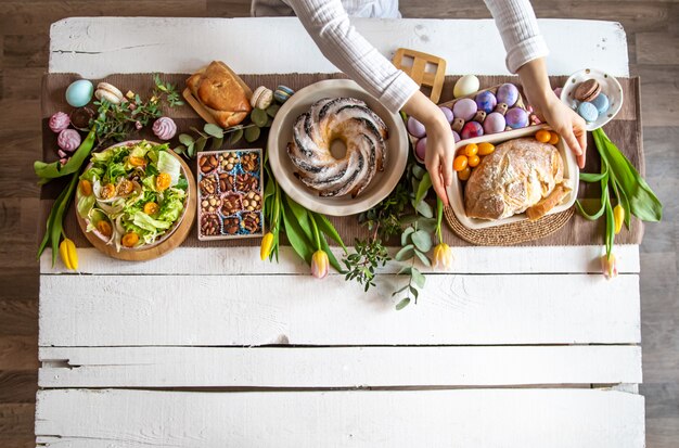 Tavola per colazione o brunch ricca di ingredienti sani per un delizioso pasto pasquale con amici e famiglia attorno al tavolo.