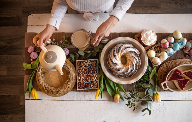 Tavola per colazione o brunch ricca di ingredienti sani per un delizioso pasto pasquale con amici e famiglia attorno al tavolo.