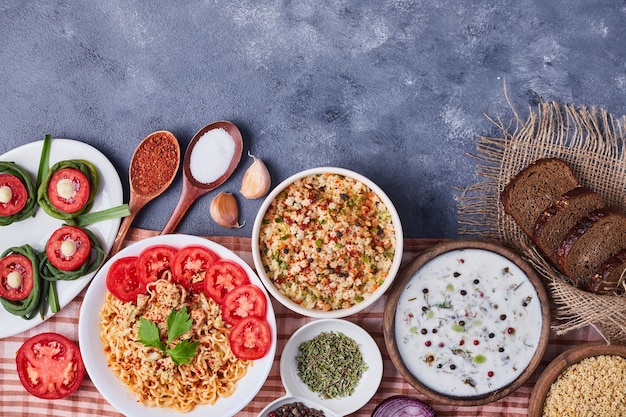 Tavolo da pranzo con cibi misti in piatti bianchi.