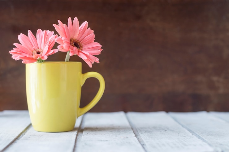 Foto gratuito tavolo di legno con bellissimi fiori su una tazza gialla