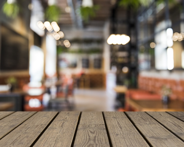 Tavolo in legno che si affaccia sul bar vuoto sfocato