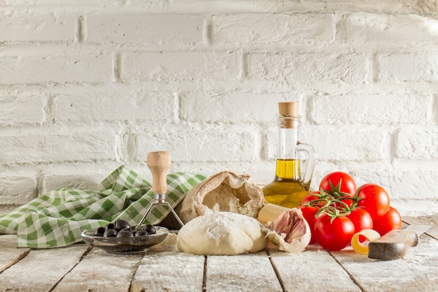 Tavolo in legno con pasta e gli ingredienti freschi