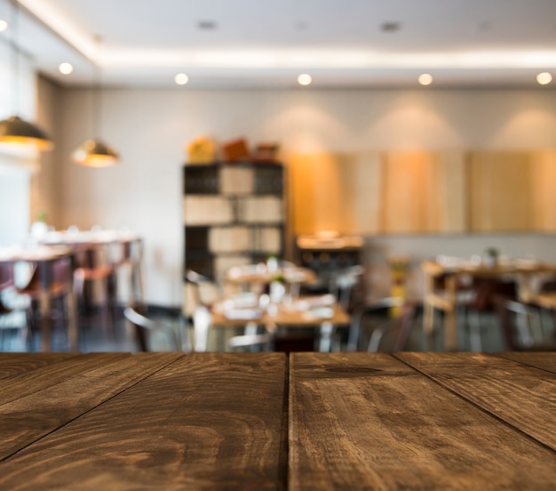 Tavolo in legno con scena ristorante offuscata