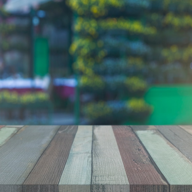 Tavolo in legno di fronte allo sfondo sfocato giardino