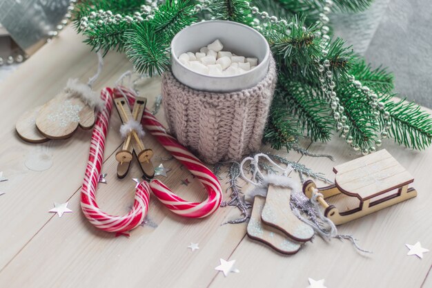 Tavolo in legno ricoperto di caramelle gommose marshmallow e decorazioni natalizie sotto le luci