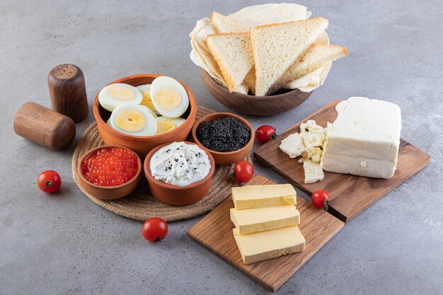 Tavolo per la colazione con uova, pane, burro e caviale.