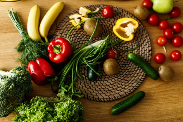 Tavolo piatto con frutta e verdura fresca, peperoni, cipolla, cetrioli, pomodori, vibrazioni sane