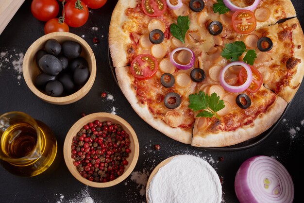 Tavolo rustico in pietra scura con vari tipi di pizza italiana, vista dall'alto. Pranzo fast food, celebrazione