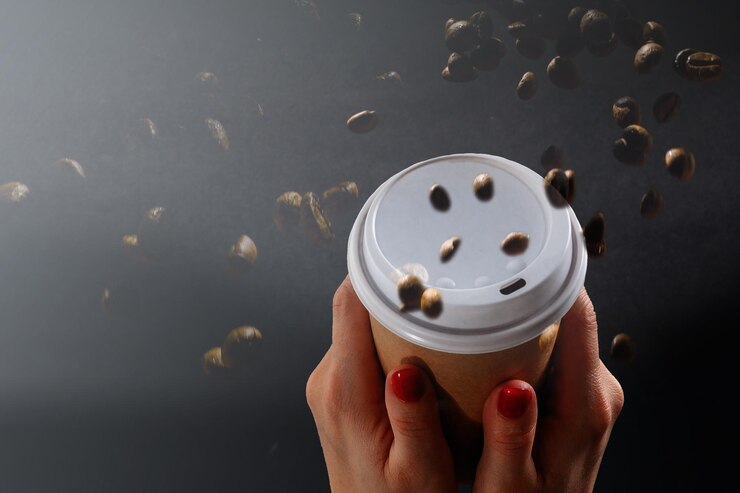 tazza da asporto con caffè e chicchi di caffè.