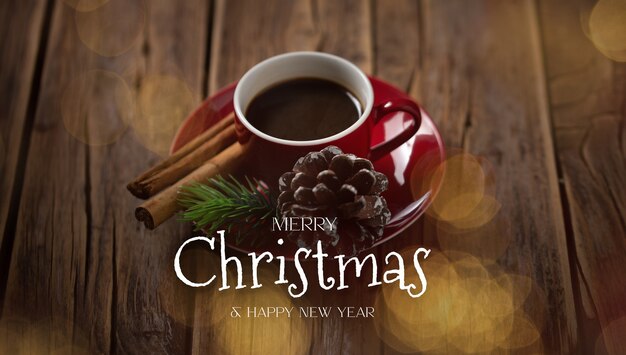 Tazza da caffè rossa con messaggio di Natale su uno sfondo di legno rustico