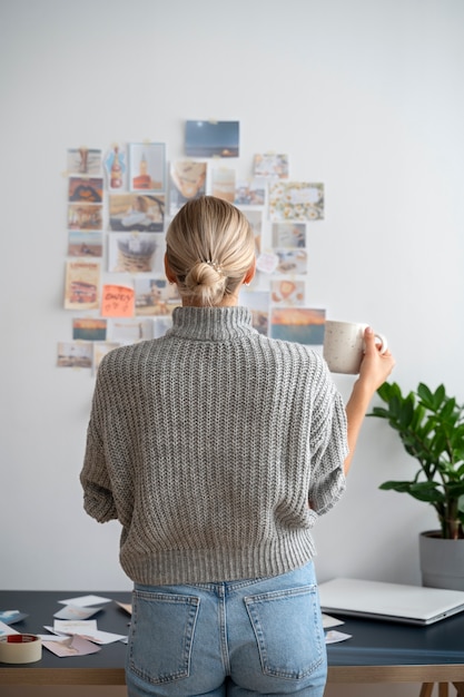 Tazza della tenuta della donna di vista posteriore