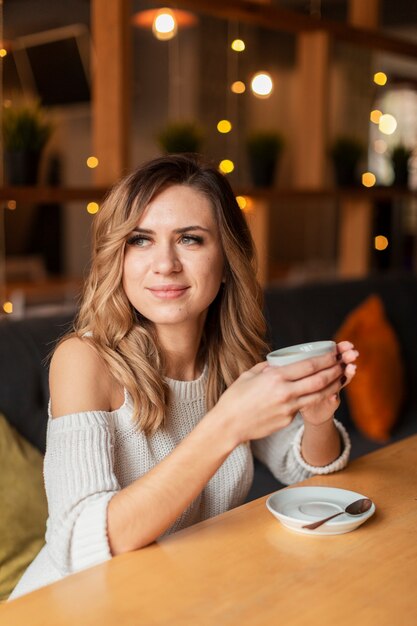 Tazza di caffè bevente della bella donna