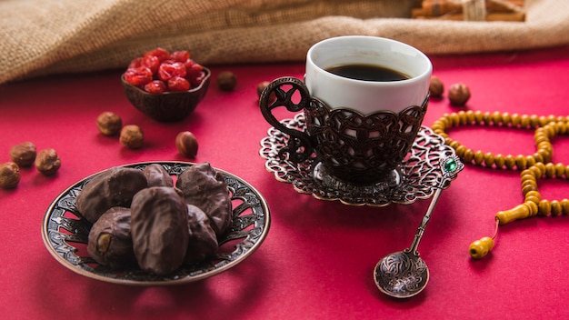 Tazza di caffè con date di frutta e perline sul tavolo