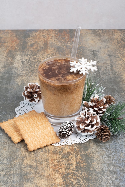 Tazza di caffè con gustosi cracker e pigne nelle quali su sfondo marmo. Foto di alta qualità