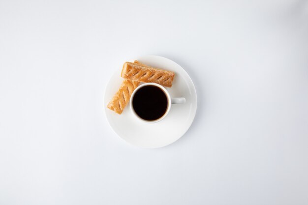 Tazza di caffè con i dolci isolati su bianco