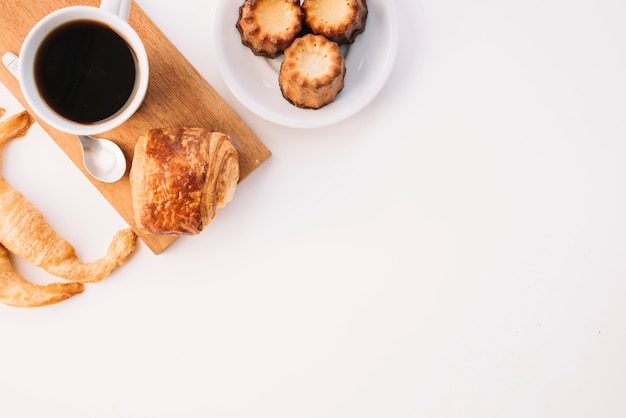 Tazza di caffè con panetteria diversa sul tavolo bianco