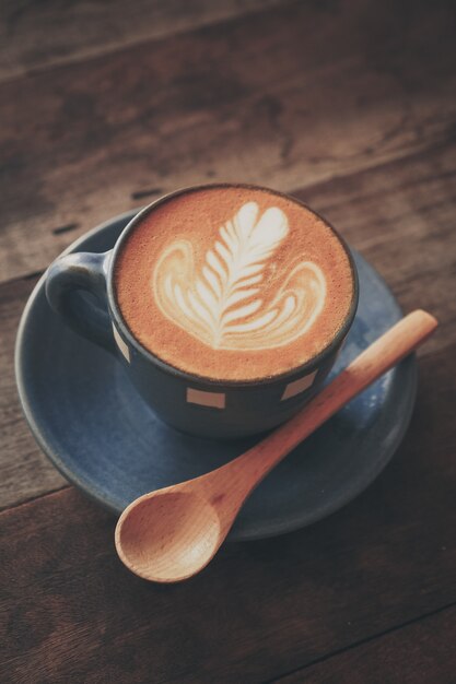 Tazza di caffè con un cucchiaio di legno su un tavolo di legno