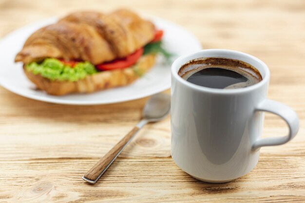 Tazza di caffè con un panino su un piatto bianco