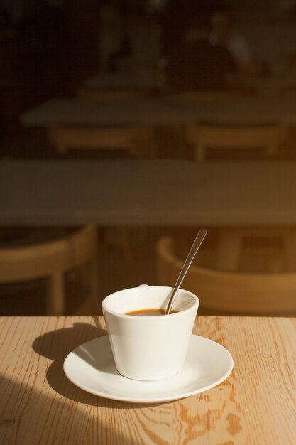 Tazza di caffè deliziosa con il piattino sulla tavola nel caf�