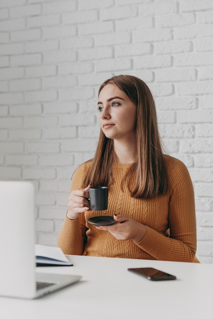 Tazza di caffè della holding della donna del colpo medio