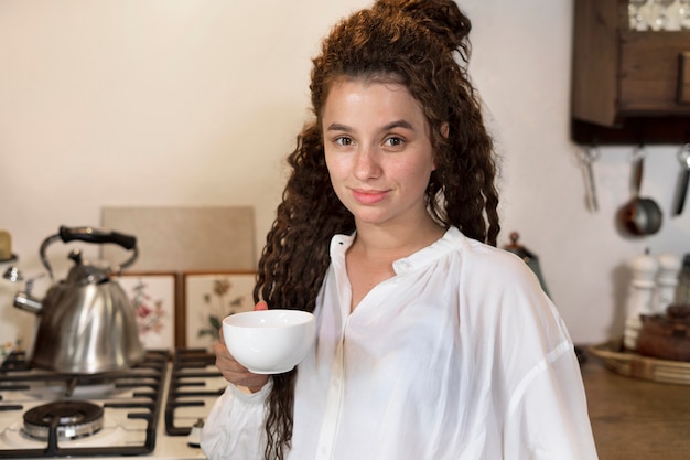 Tazza di caffè della holding della donna del colpo medio