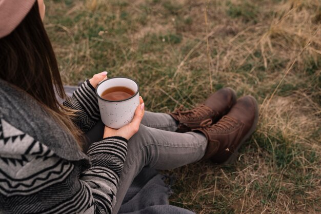 Tazza di caffè della holding della donna del primo piano