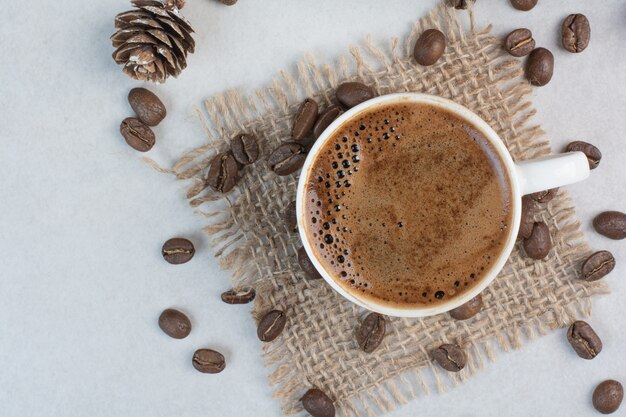 Tazza di caffè e chicchi di caffè su tela di sacco. Foto di alta qualità