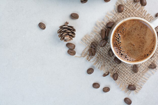 Tazza di caffè e chicchi di caffè su tela di sacco. Foto di alta qualità