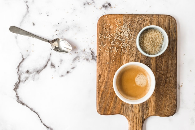 Tazza di caffè e ciotola di zucchero sul contesto di marmo bianco