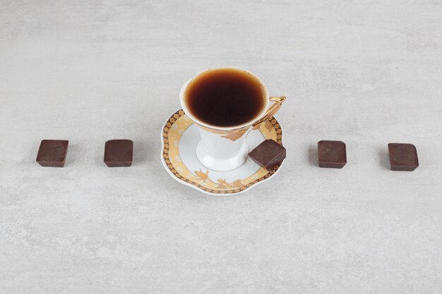 Tazza di caffè espresso con pezzi di cioccolato sulla superficie in marmo