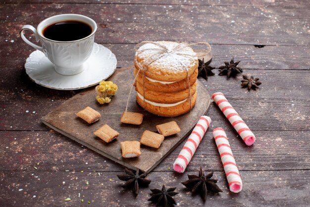 tazza di caffè forte e caldo insieme a biscotti e biscotti sandwich su legno, torta di biscotti cuocere alla frutta dolce