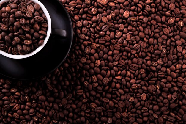 Tazza di caffè nero con sfondo di chicchi di caffè tostato