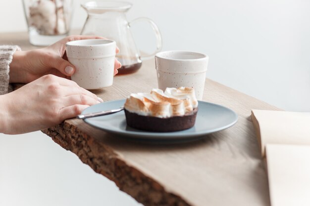 Tazza di caffè, ramo di un albero, davanzale in legno