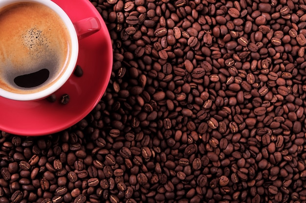 Tazza di caffè rosso con vista dall&#39;alto di chicchi di caffè e tostato