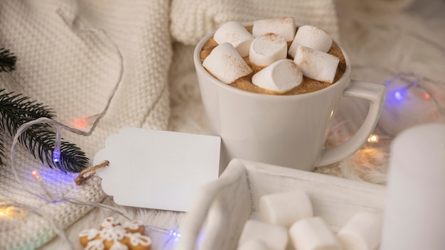 Tazza di cioccolata calda con marshmallow e maglione con etichetta