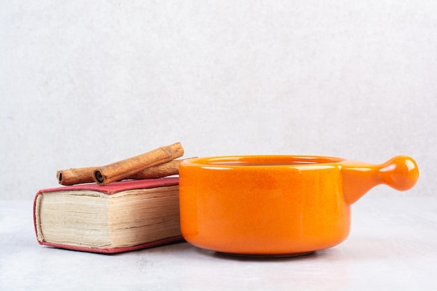 Tazza di cioccolata calda, libro e cannella su sfondo grigio. Foto di alta qualità