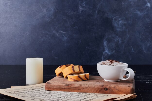 Tazza di latte con polvere di caffè e panini.