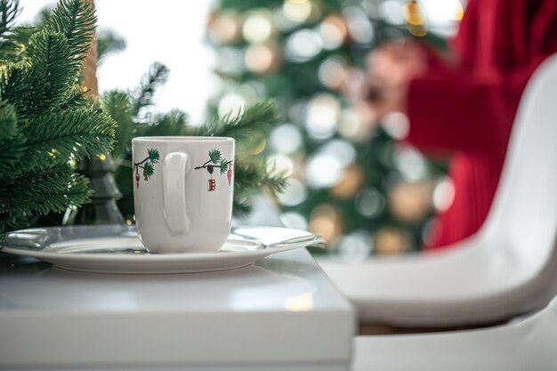 Tazza di Natale in cucina su uno sfondo sfocato con bokeh, copia spazio.